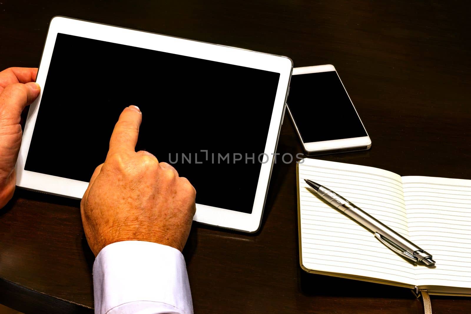 Businessman hand holding touch screen device and pointing
