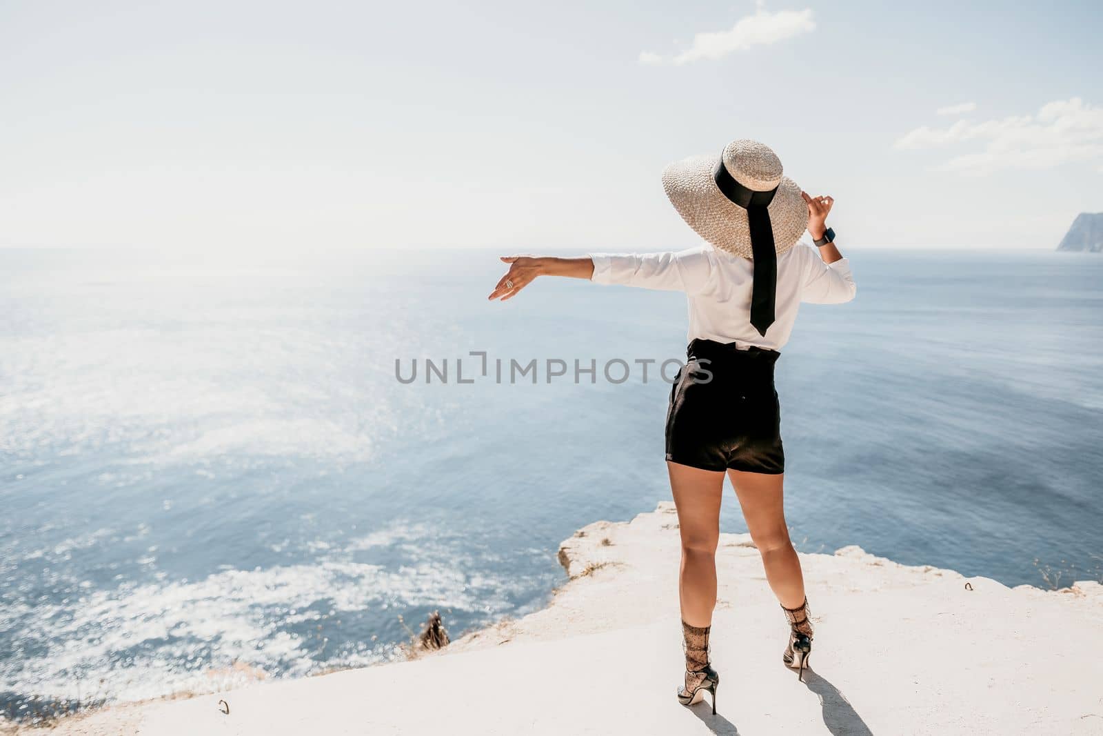 Woman sea hat. Business woman in yellow hat freelancer working over blue sea beach. Girl relieves stress from work. Freelance, digital nomad, travel and holidays concept by panophotograph