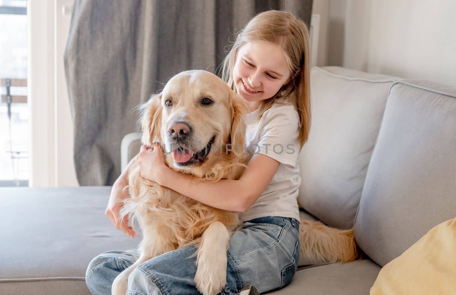 Preteen girl with golden retriever dog at home by tan4ikk1