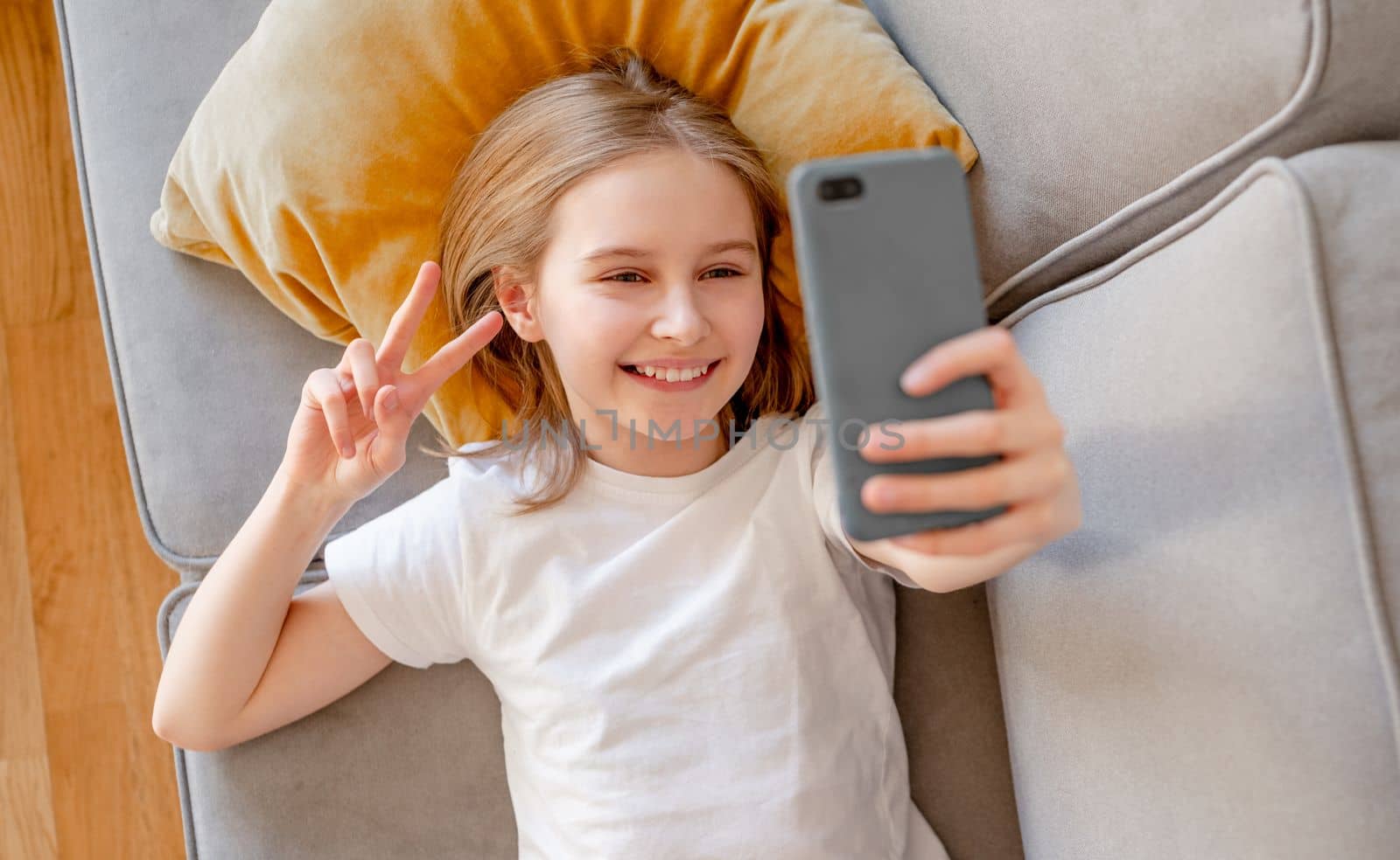 Preteen girl with smartphone at home by tan4ikk1