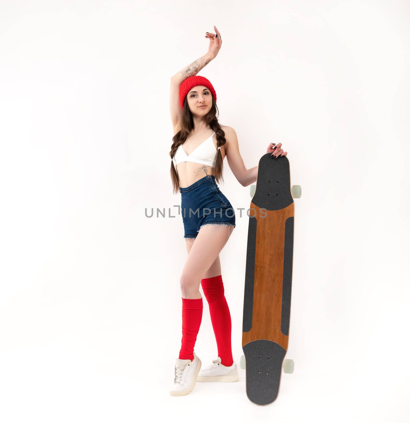 sexy girl in a fashionable red hat with a longboard on a white background copy paste