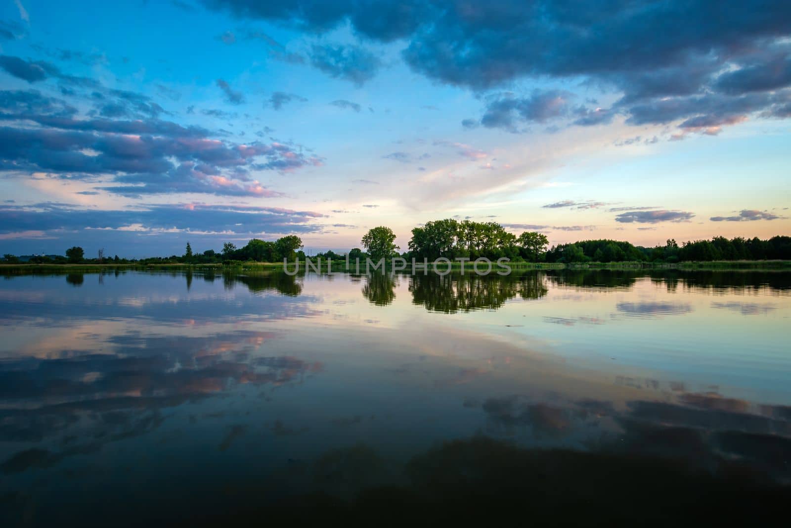 Reflection of evening clouds in the water of a calm lake, Stankow, Poland by darekb22
