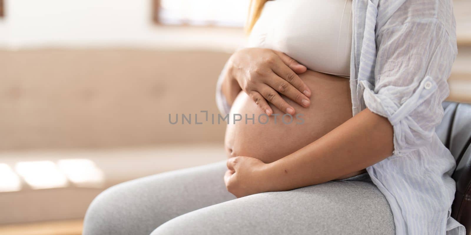 pregnancy, rest, people and expectation concept - happy pregnant woman and touching her belly at home.
