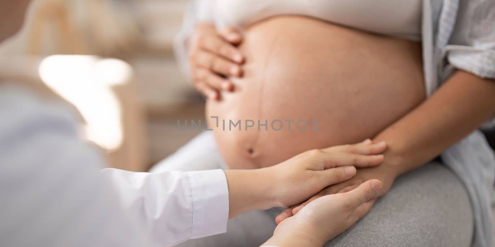 Healthcare, pregnancy and hands of doctor with pregnant woman for support, comfort and compassion. Medical care, family home and top view of health worker holding hands with maternal patient.