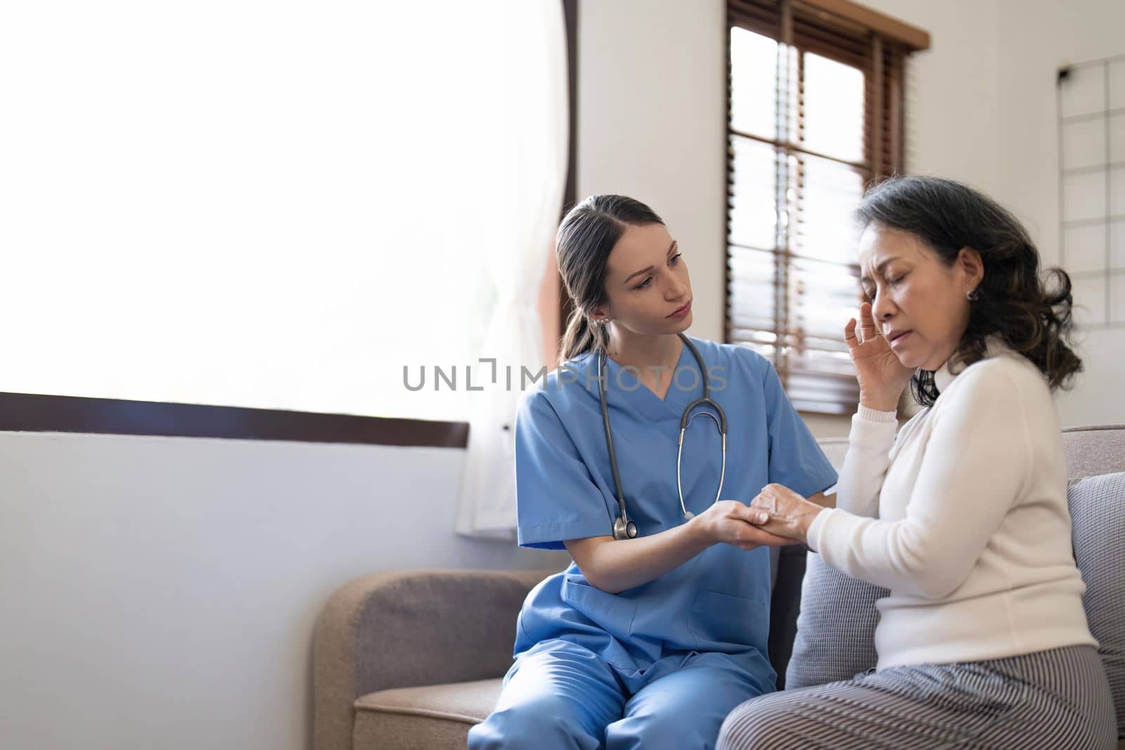 Female nurse visit old grandmother patient at home listen to complains concerns, attentive young woman doctor consulting mature senior grandma, elderly medical healthcare concept.
