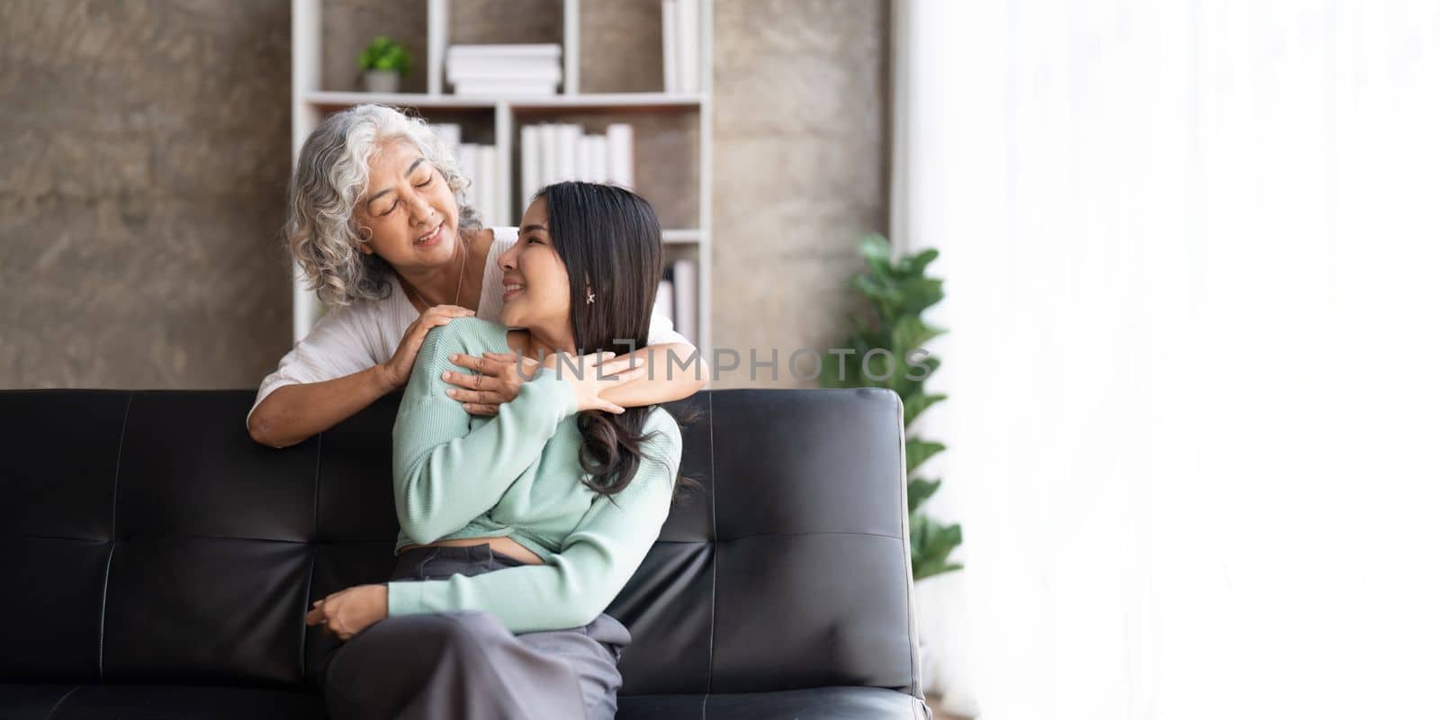 Mother and daughter hugging at home. Happy senior mom and adult daughter embracing with love.