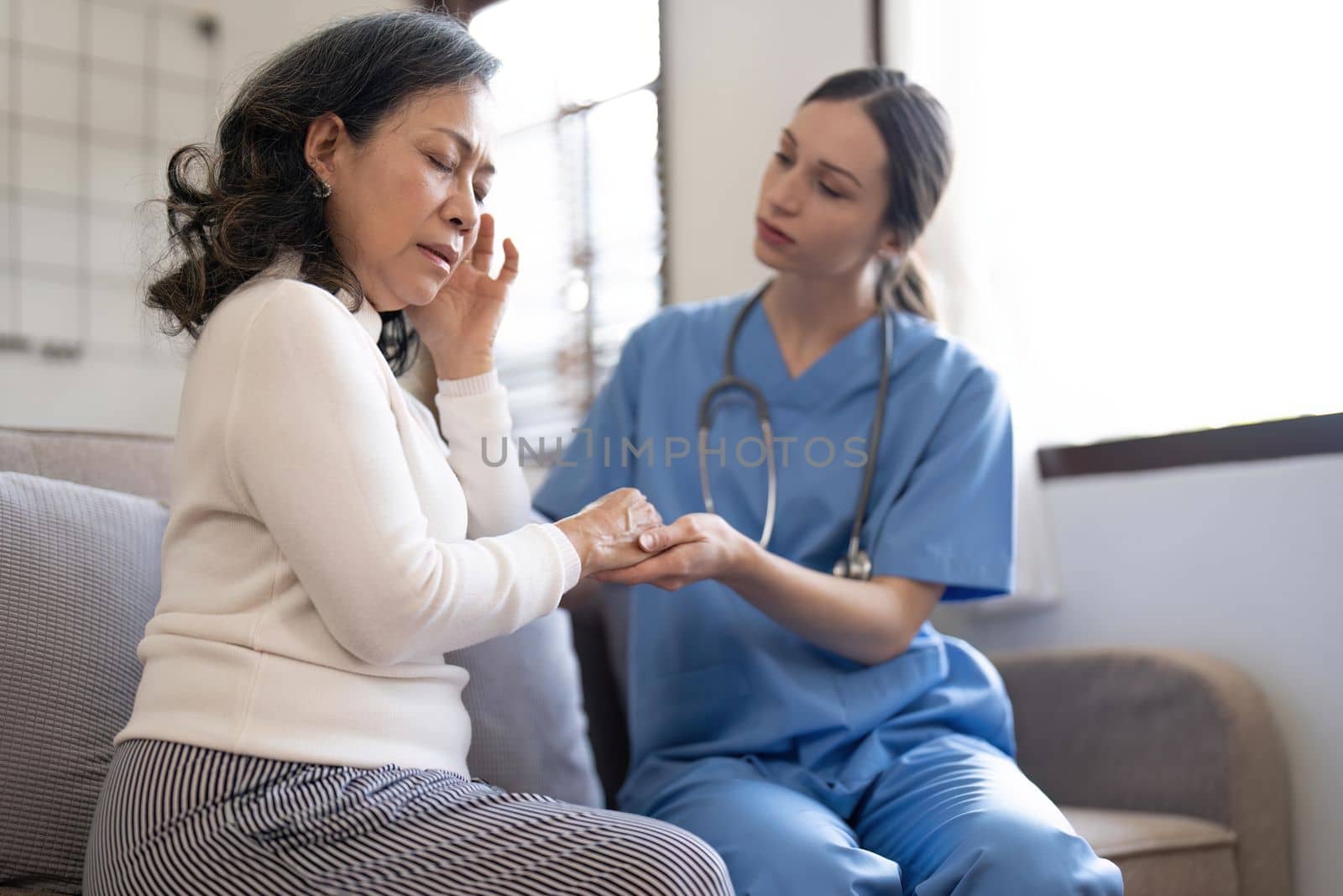 Female nurse visit old grandmother patient at home listen to complains concerns, attentive young woman doctor consulting mature senior grandma, elderly medical healthcare concept.