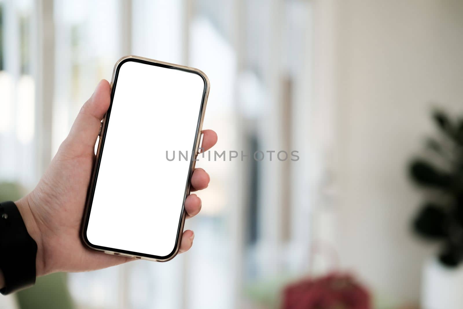 Mock up phone in woman hand showing white screen. Mobile phone white screen is blank the background is blurred.