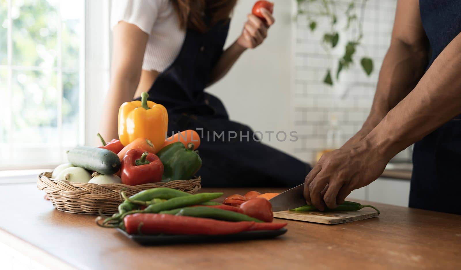 Romantic couple is cooking on kitchen. Handsome man and attractive young woman are having fun together while making salad. Healthy lifestyle concept...