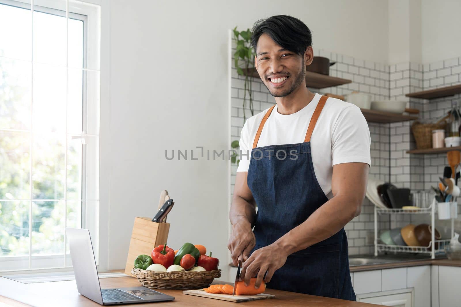 An Asian young man cooking , preparing breakfast with healthy food in kitchen at home , healthy lifestyle..