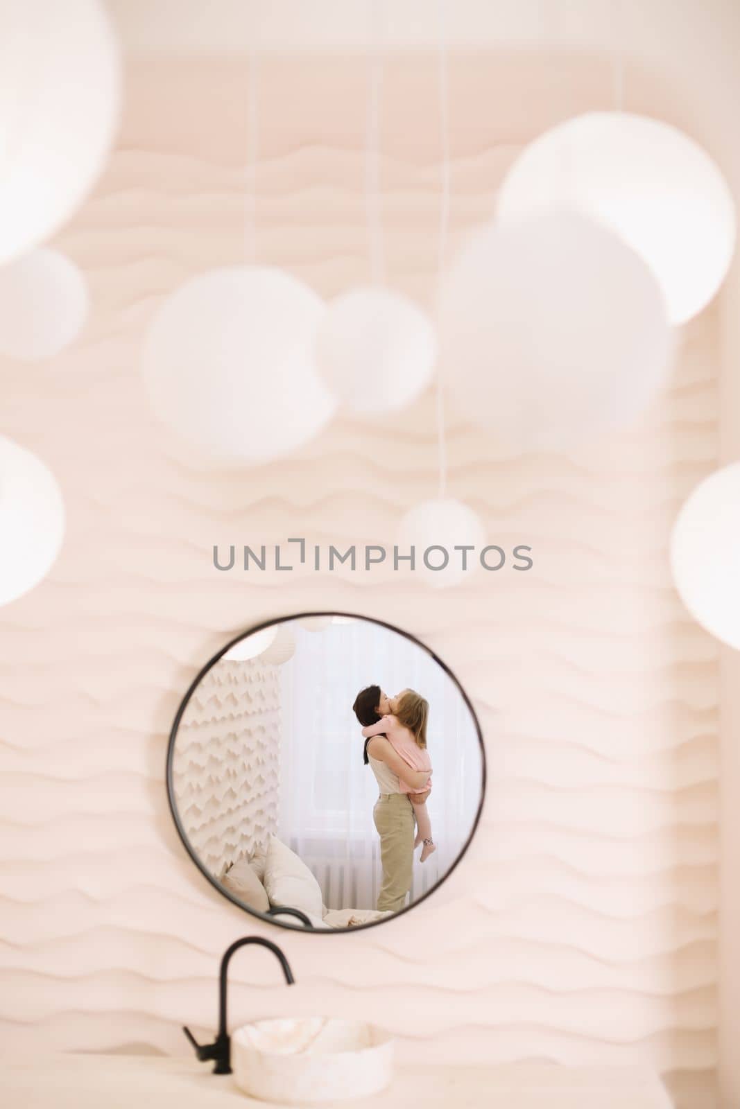 Woman in light clothes have fun with cute child baby girl 3 years old. Mommy little kid daughter on beige background studio portrait. Mother's Day love family parenthood childhood concept by paralisart