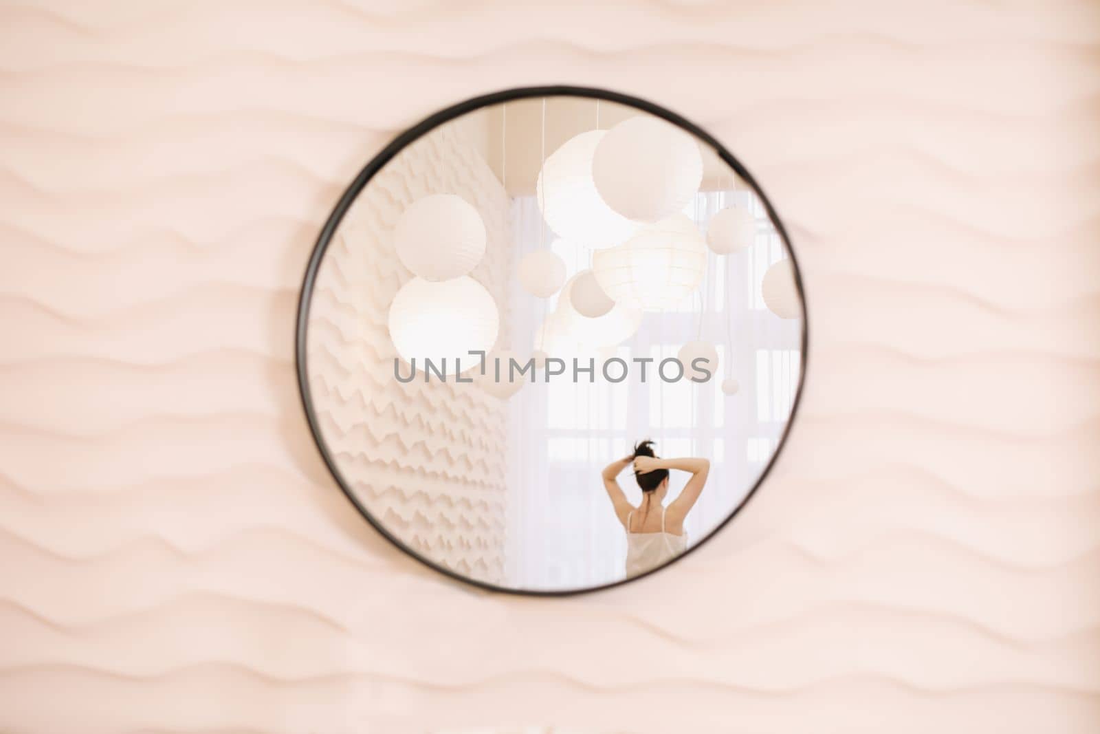 Portrait of calm pretty girl. Portrait of the woman reflected in mirror in a cozy light room in the morning