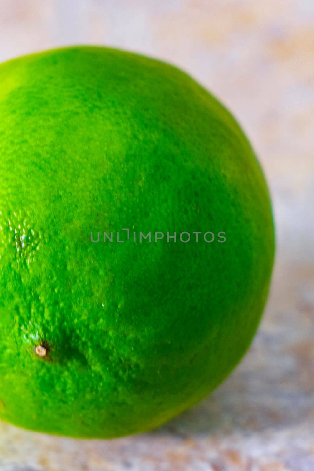 Green ripe lime lime citrus fruit on the table in Mexico. by Arkadij