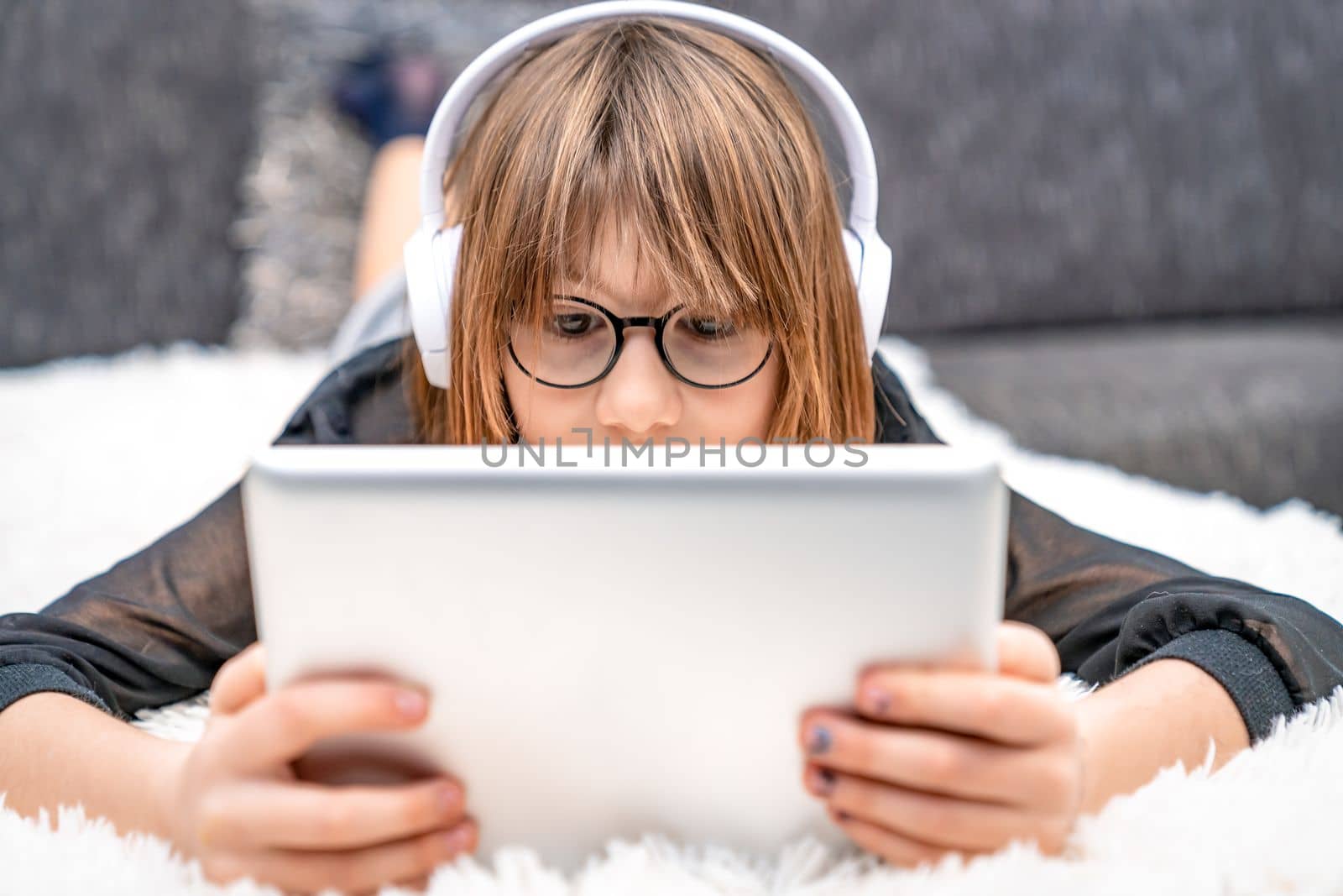 teenager with headphones and tablet on couch. children and modern technology, generation z by Edophoto