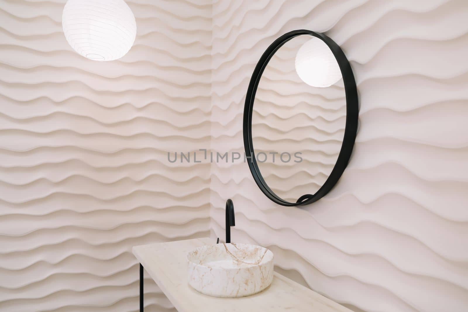 Modern interior with stylish round mirror by beige wall in a cozy room, copy space, elegant accessories in stylish home decor.