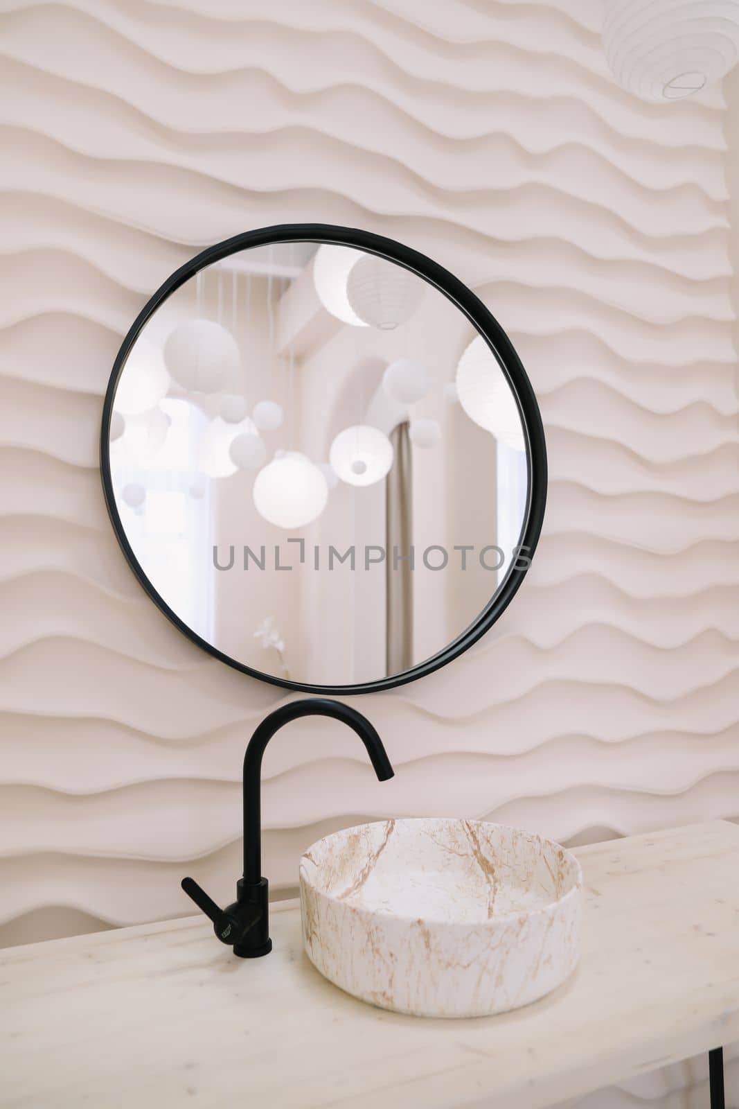Modern interior with stylish round mirror by beige wall in a cozy room, copy space, elegant accessories in stylish home decor.