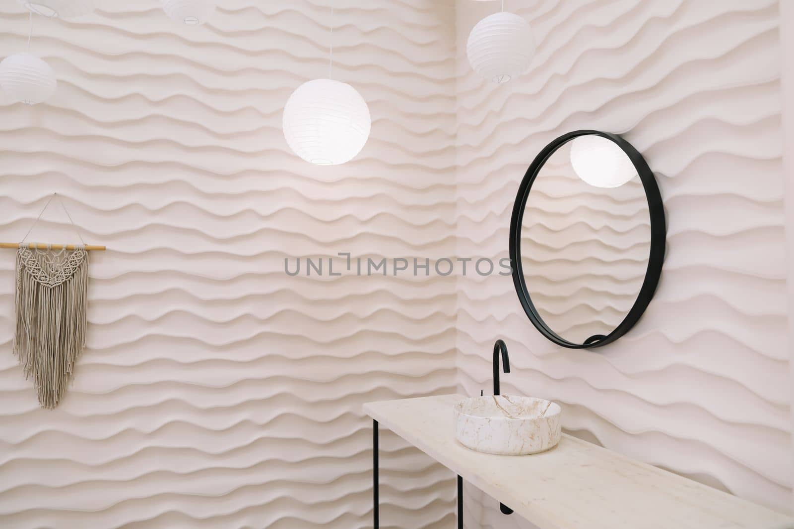 Modern interior with stylish round mirror by beige wall in a cozy room, copy space, elegant accessories in stylish home decor.