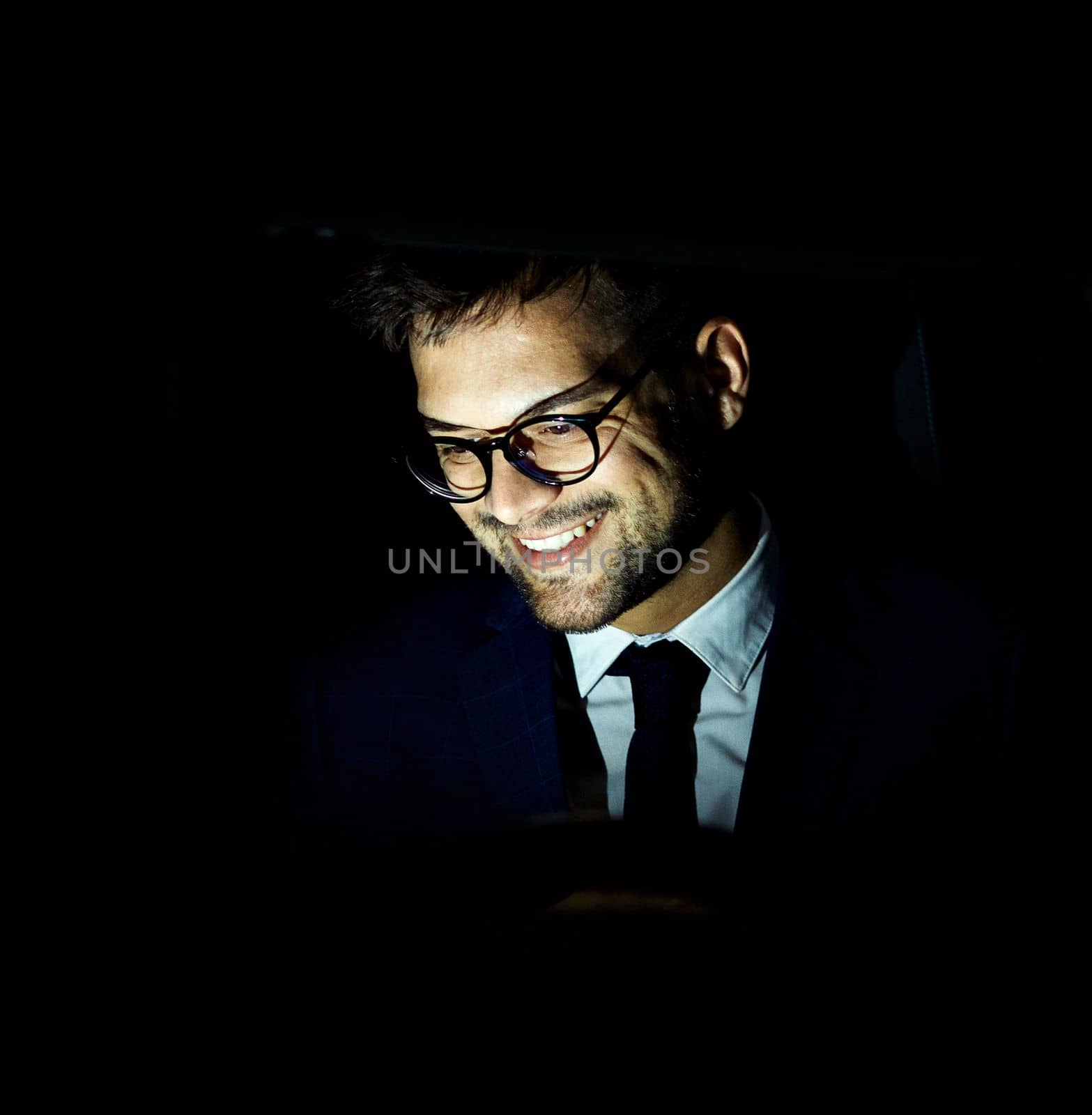 Portrait of a young businessman with tablet or laptop working late at night in office