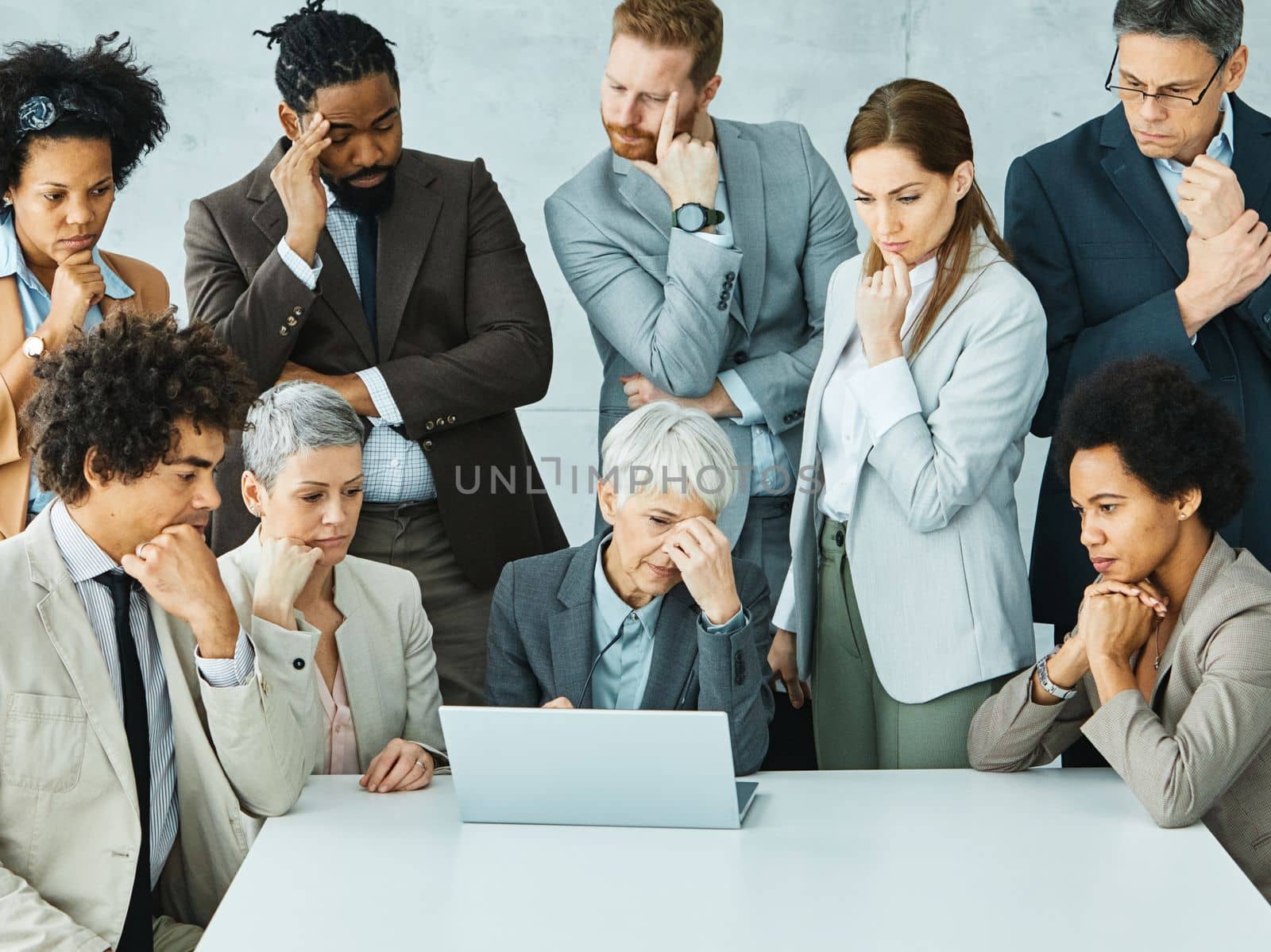 Group of young and senior business people having a meeting and being worried and stressed over a an arised problem in the office. Teamwork and success concept