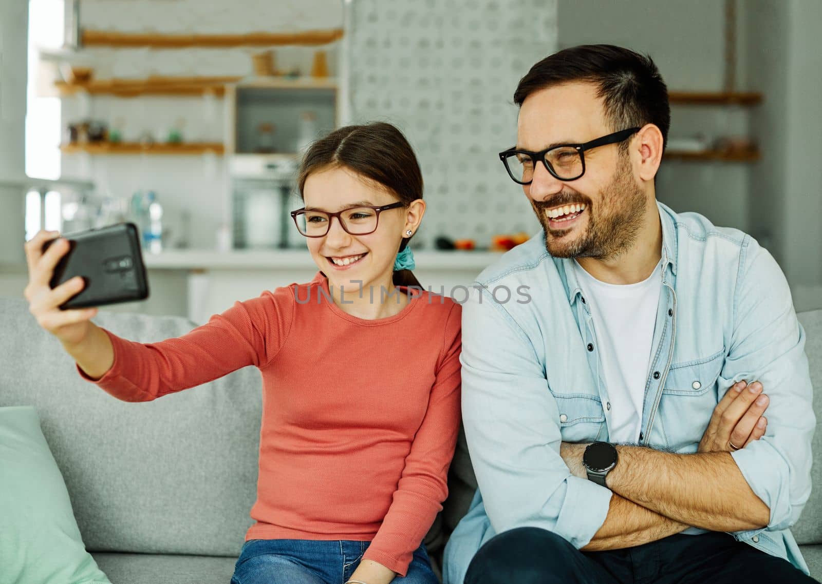 Family father and daughter having fun playing and taking selfie at home