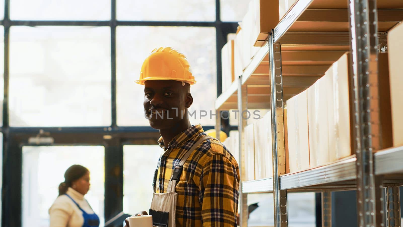 Male storage room employee standing near racks by DCStudio