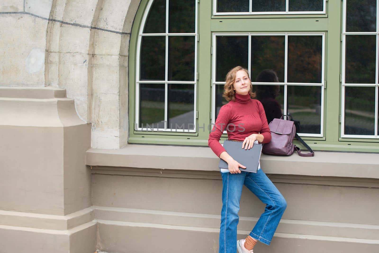 young caucasian girl going back to college, standing with a backpack and notebooks and smiling, back to school, High quality photo