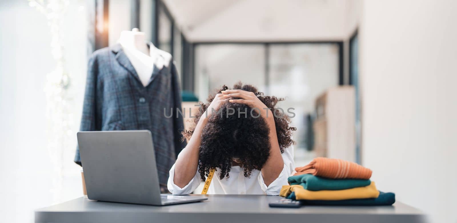 a Asian woman, a stylish fashion designer, thinking of problem to working, tried to new project, while a young businesswoman tries to recover after a long day's work in a clothing store