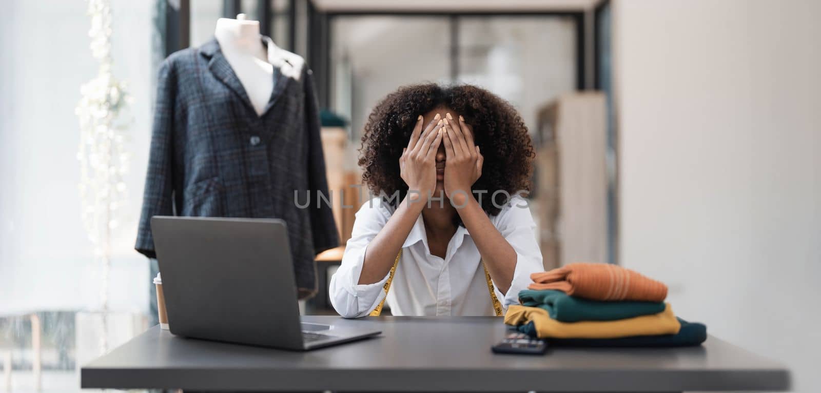 a Asian woman, a stylish fashion designer, thinking of problem to working, tried to new project, while a young businesswoman tries to recover after a long day's work in a clothing store