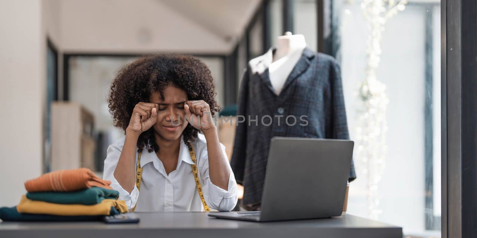 a Asian woman, a stylish fashion designer, thinking of problem to working, tried to new project, while a young businesswoman tries to recover after a long day's work in a clothing store