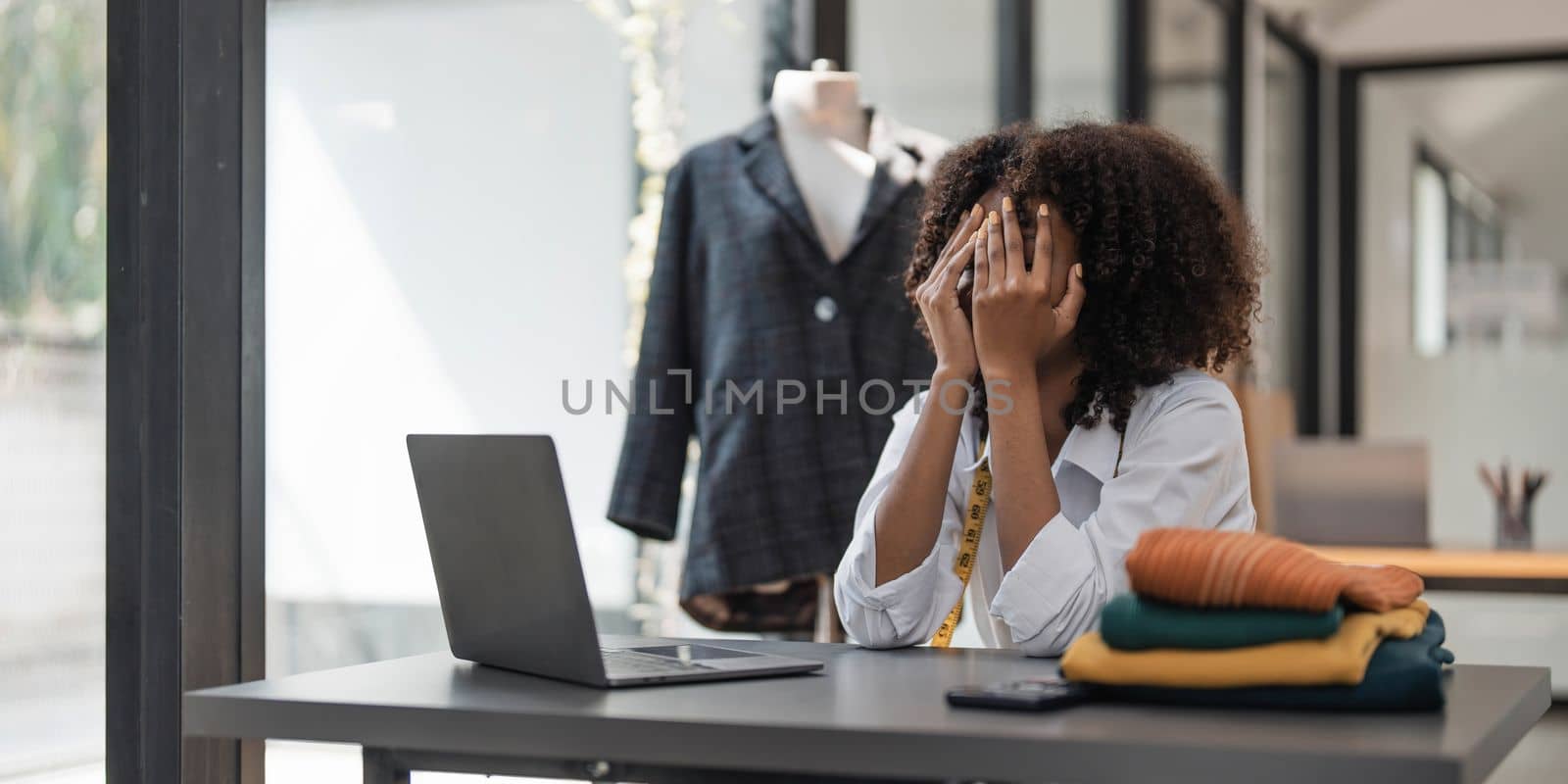 a Asian woman, a stylish fashion designer, thinking of problem to working, tried to new project, while a young businesswoman tries to recover after a long day's work in a clothing store
