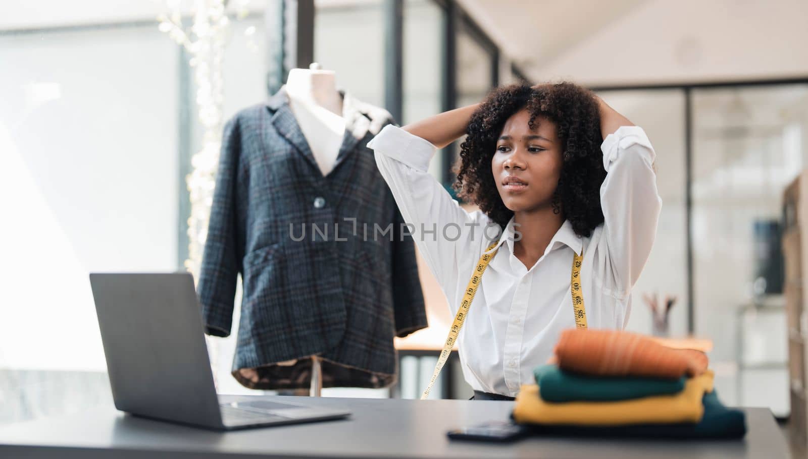 a Asian woman, a stylish fashion designer, thinking of problem to working, tried to new project, while a young businesswoman tries to recover after a long day's work in a clothing store