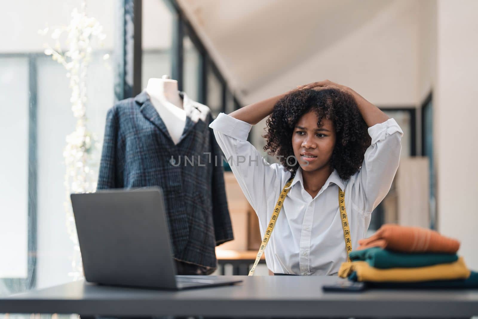 a Asian woman, a stylish fashion designer, thinking of problem to working, tried to new project, while a young businesswoman tries to recover after a long day's work in a clothing store. by wichayada