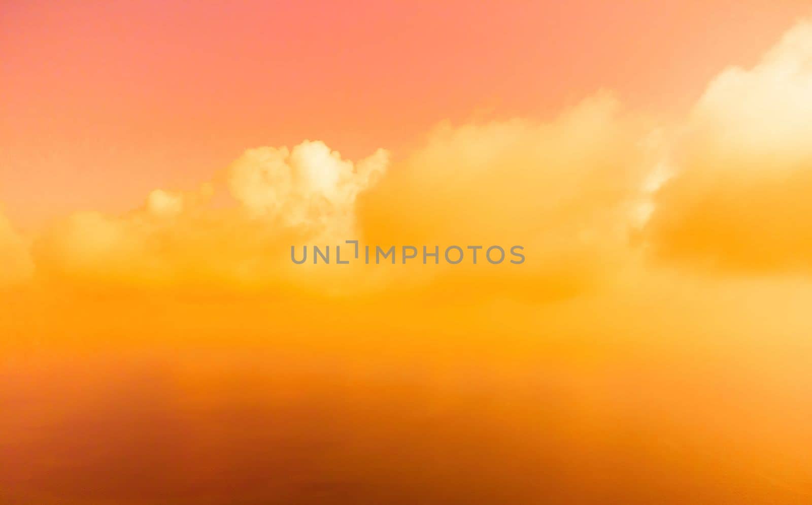 A red burning sunset with the silhouette of a cliff over the sea. Abstract nature summer or spring ocean sea background. Small waves on golden warm water surface with bokeh lights from sun.