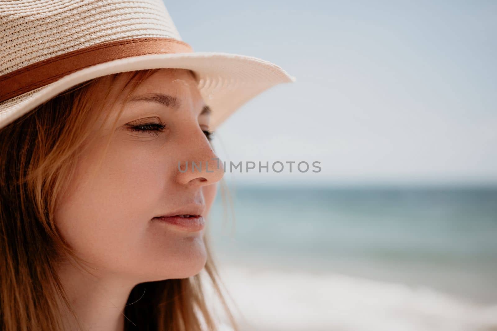 Young woman in red bikini on Beach. Blonde in sunglasses on pebble beach enjoying sun. Happy lady in one piece red swimsuit relaxing and sunbathing by turquoise sea ocean on hot summer day. Close up,