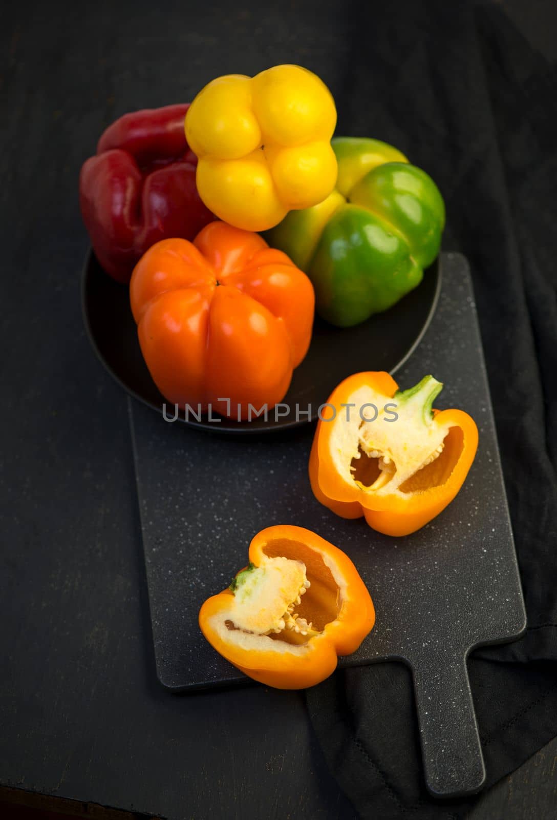 colored peppers on black background
