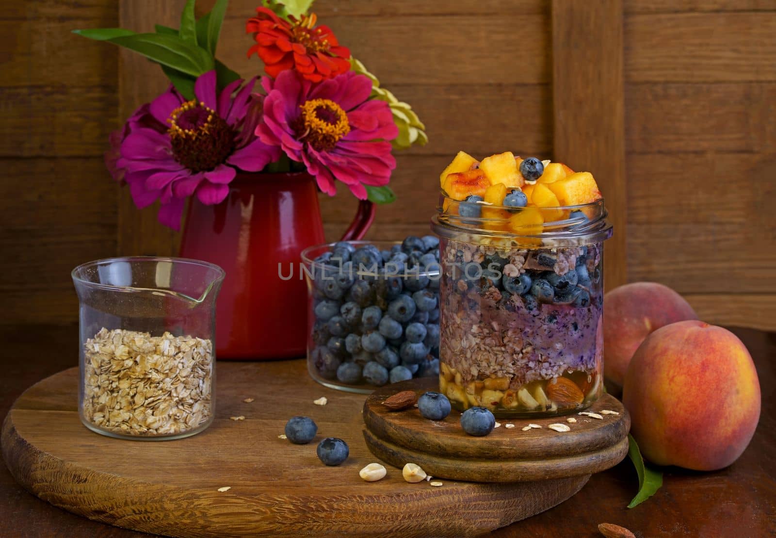 Homemade granola, muesli with blueberry and yogurt in glasses on rustic wooden background. Healthy breakfast. by aprilphoto