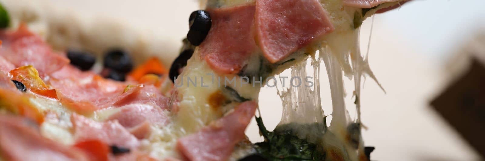 Hand holds pizza cheese ham and olives box. Delicious fresh pizza and delivery concept