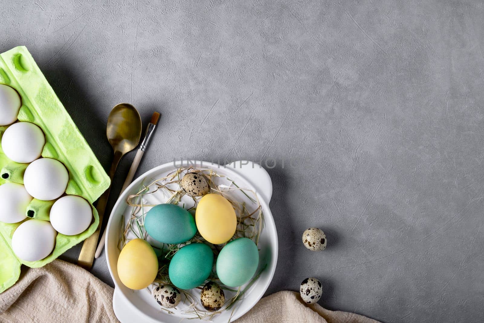 Easter composition with chicken and quail eggs, cardboard container for eggs. Copy space.