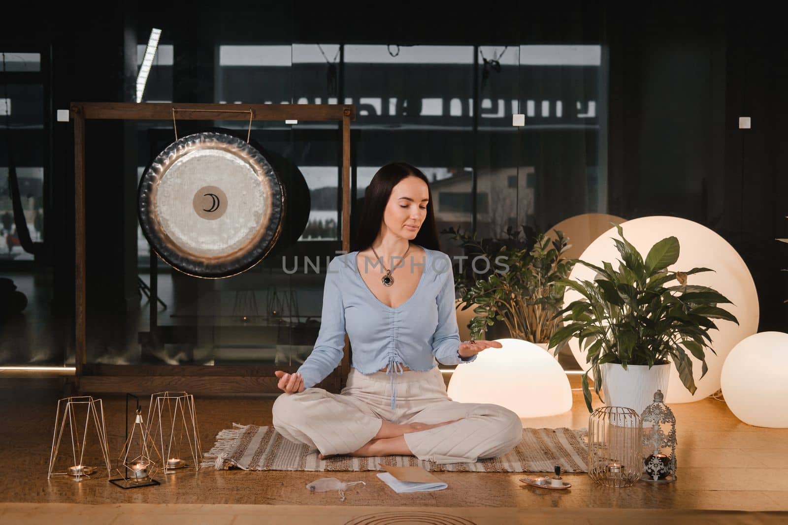 A young woman sitting in the Lotus position before the Game was playing and holding game cubes in her hand.