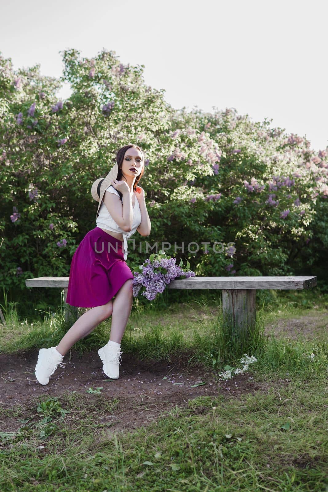 A fashionable girl with dark hair, a spring portrait in lilac tones in summer. Bright professional makeup