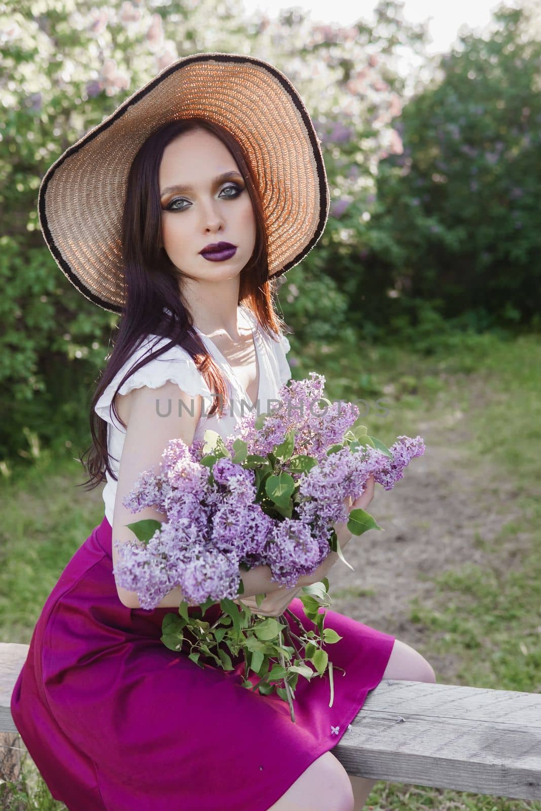 A fashionable girl with dark hair, a spring portrait in lilac tones in summer. Bright professional makeup