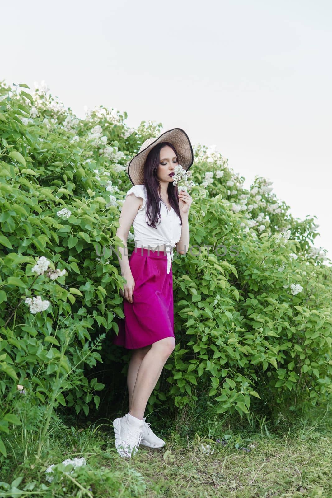 A fashionable girl with dark hair, a spring portrait in lilac tones in summer. Bright professional makeup