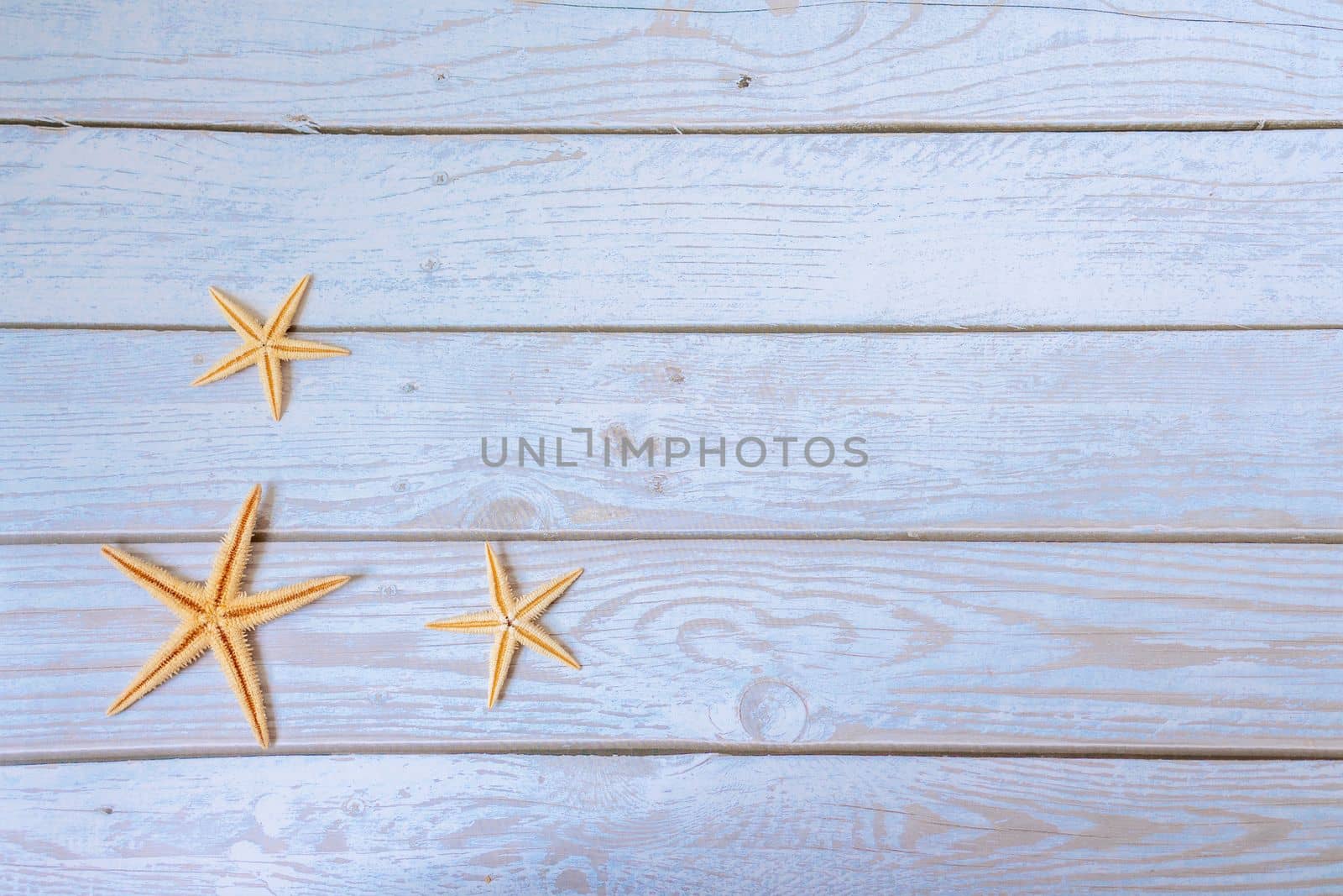 Sea stars. Summer nautical background - stars on wooden blue background by Matiunina