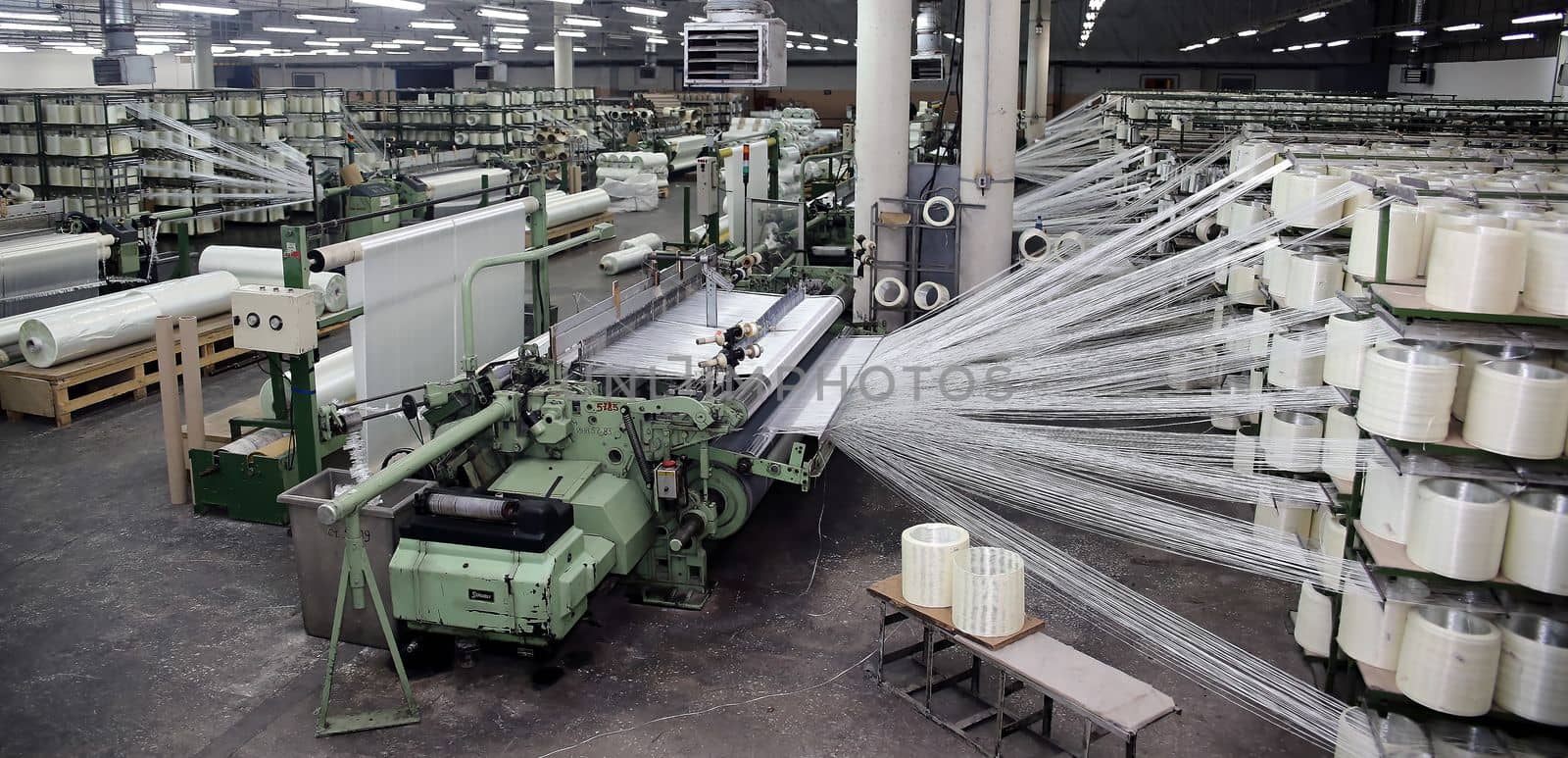 Woven fiberglass roving in a soft cockpit. Fiberglass spools in the workshop.