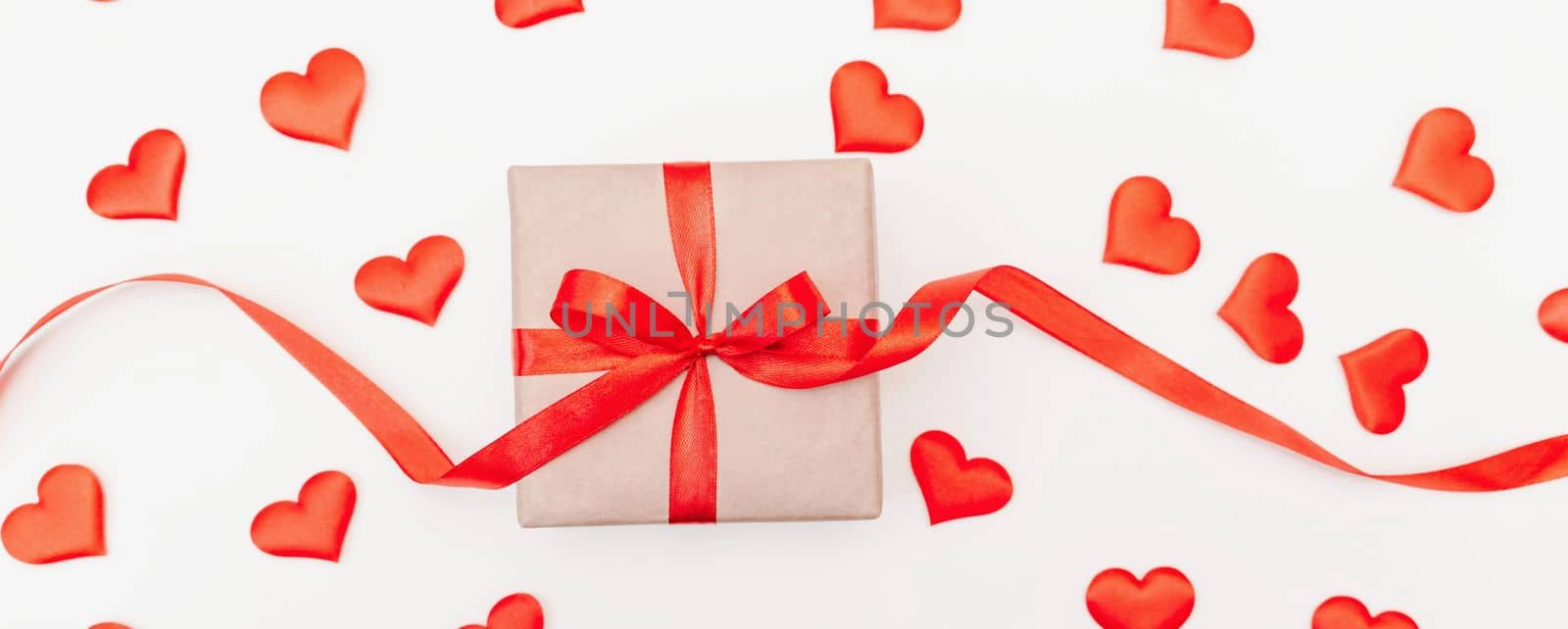 Baner Hearts gift box with a red bow on a white background with red hearts. Festive web banner. View from above. by Matiunina