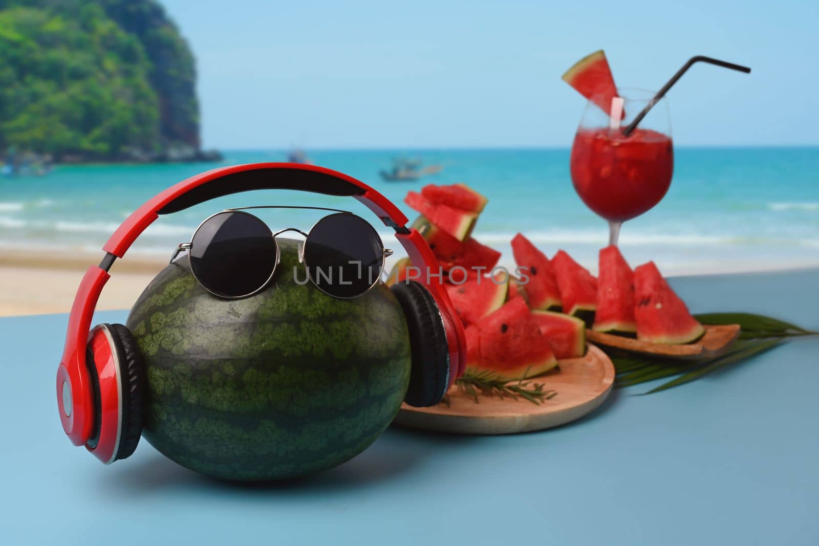 Whole watermelon and watermelon smoothie on table with beautiful summer beach in background. by prathanchorruangsak
