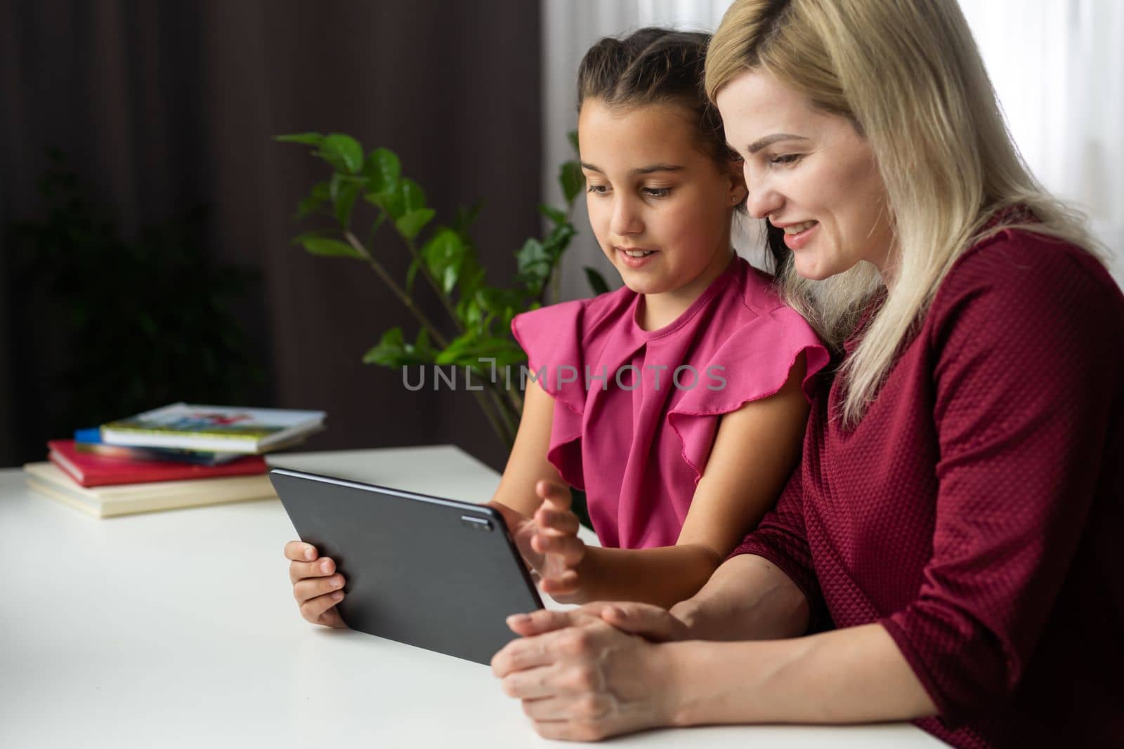 Mom with her tween daughter using tablet together