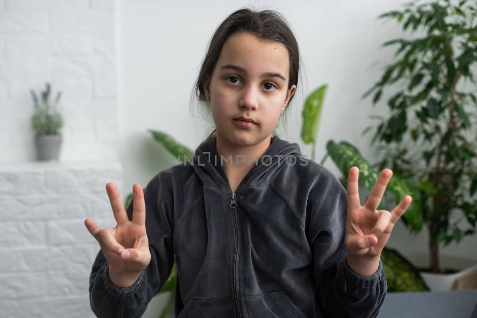 Cute deaf mute girl using sign language on light background by Andelov13