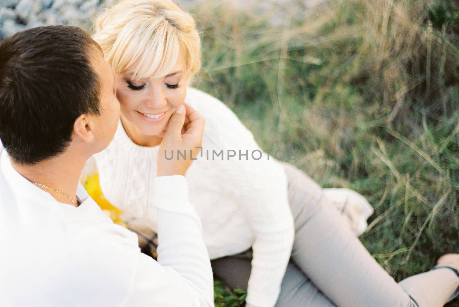 Man touches woman face with his hand and kisses her on the cheek. High quality photo