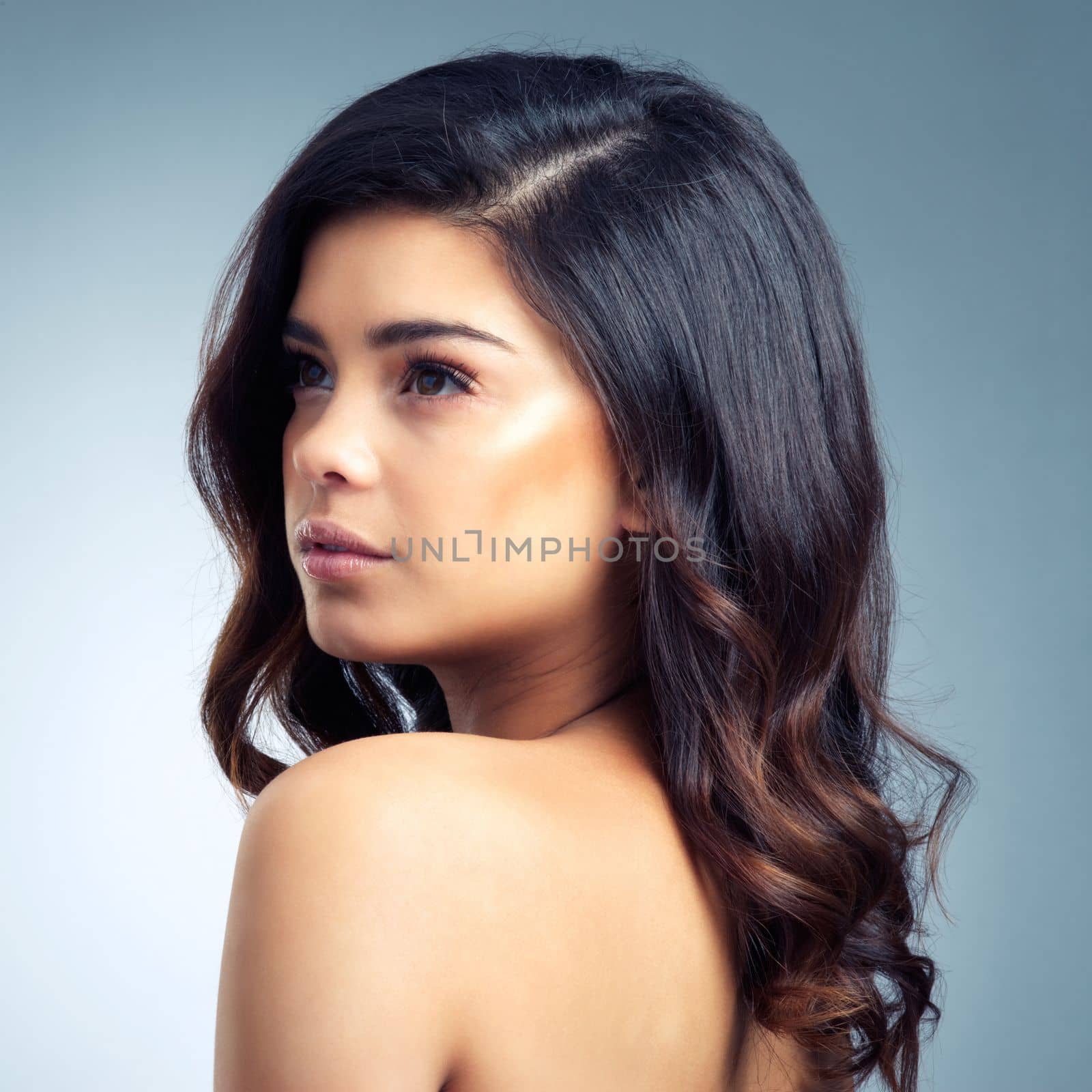 Her beauty is beyond compare. Studio shot of a beautiful young woman posing against a gray background